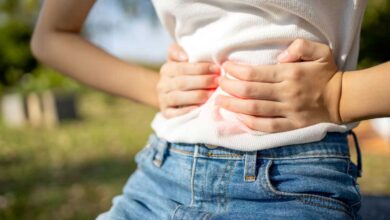 donna che si appoggia le mani sulla pancia perché ha alterazioni del microbiota in estate