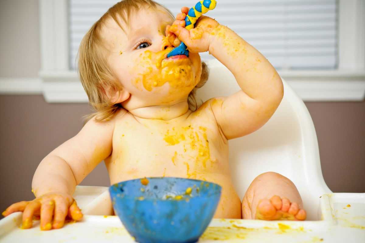 neonato che mangia da solo pappa fatta in casa e si sporca