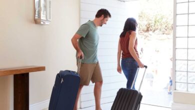 coppia che lascia la casa con le valigie perché sono in partenza per le vacanze