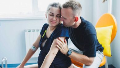 donna incinta pronta a partorire con suo marito alle spalle che la sostiene