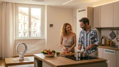 coppia che cucina in casa mentre si raffresca con un ventilatore senza pale