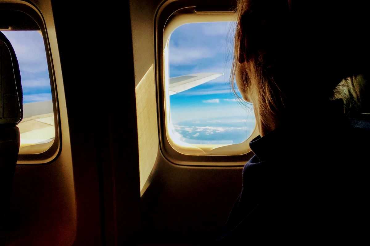 donna che guarda fuori dal finestrino dell'aereo