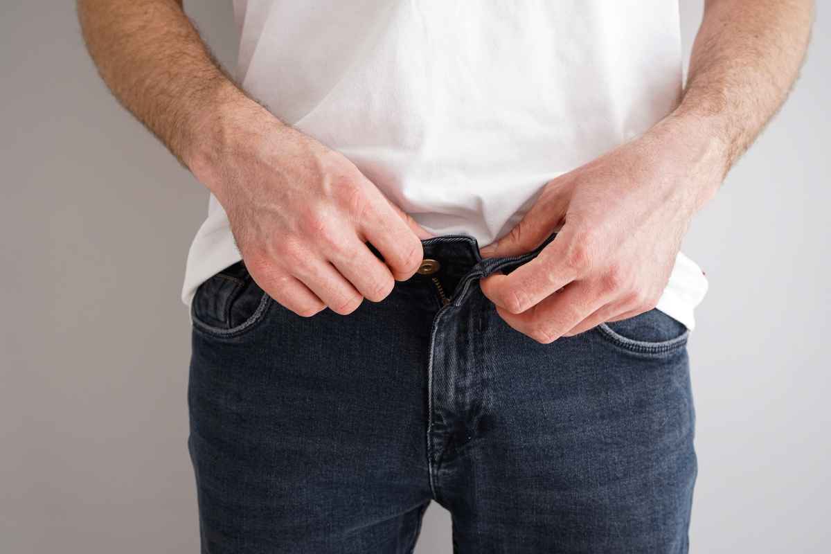 un uomo si sbottona i pantaloni