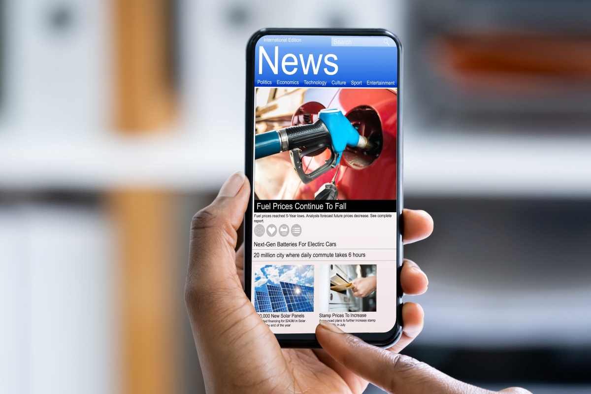 primo piano su due mani che scrollano le notizie su un cellulare