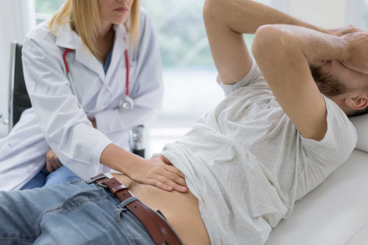 un medico visita un paziente che ha un forte dolore addominale