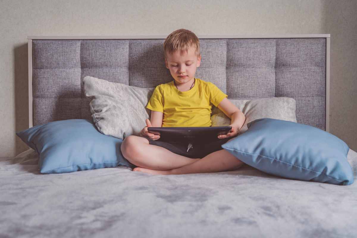 un bambino con un tablet sulle gambe