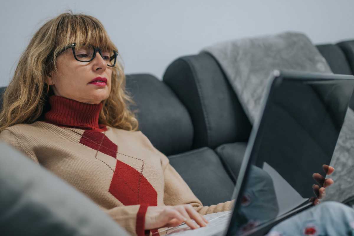 una donna guarda il computer seduta sul divano