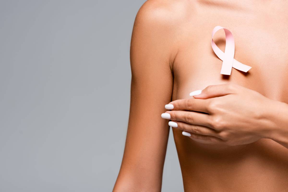 una donna a seno scoperto con il simbolo della lotta al tumore al seno
