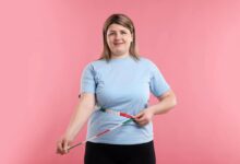 una donna curvy con un metro da sarta come cintura