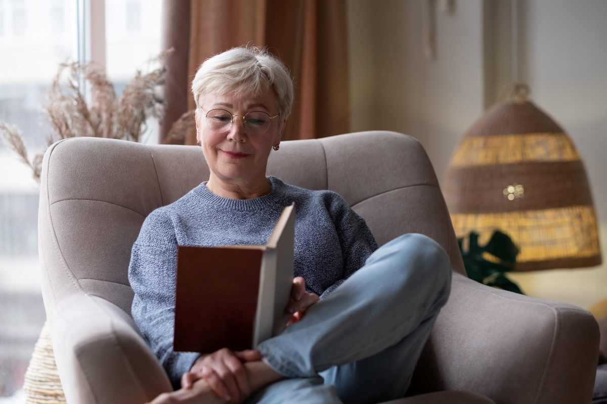 una donna sorridente legge un libro