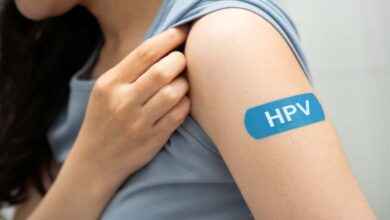 una ragazza mostra il cerotto sulla spalla con la scritta hpv
