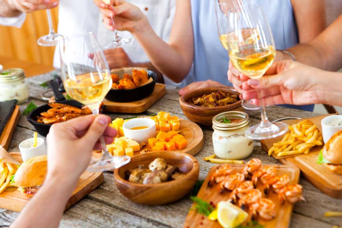 persone che fanno un aperitivo con cibi salati e alcolici