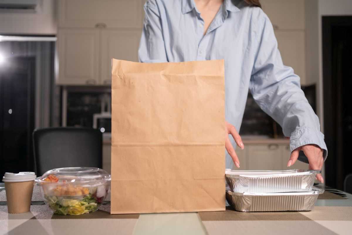 donna che ha ricevuto cibo d'asporto e svuota il sacchetto