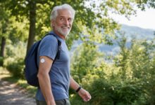 uomo che cammina nel verde con dispositivo per il monitoraggio continuo del glucosio sul braccio
