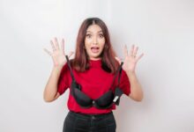 una donna spaventata con in mano un reggiseno