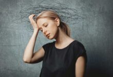 donna con preoccupazioni che si porta la mano alla testa