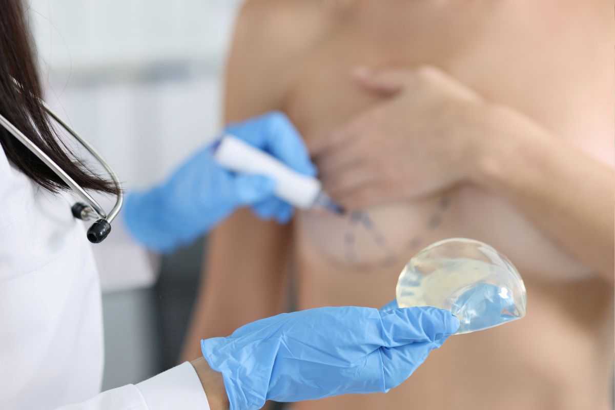 medico prepara la donna all'operazione di mastoplastica additiva con inserimento protesi al seno