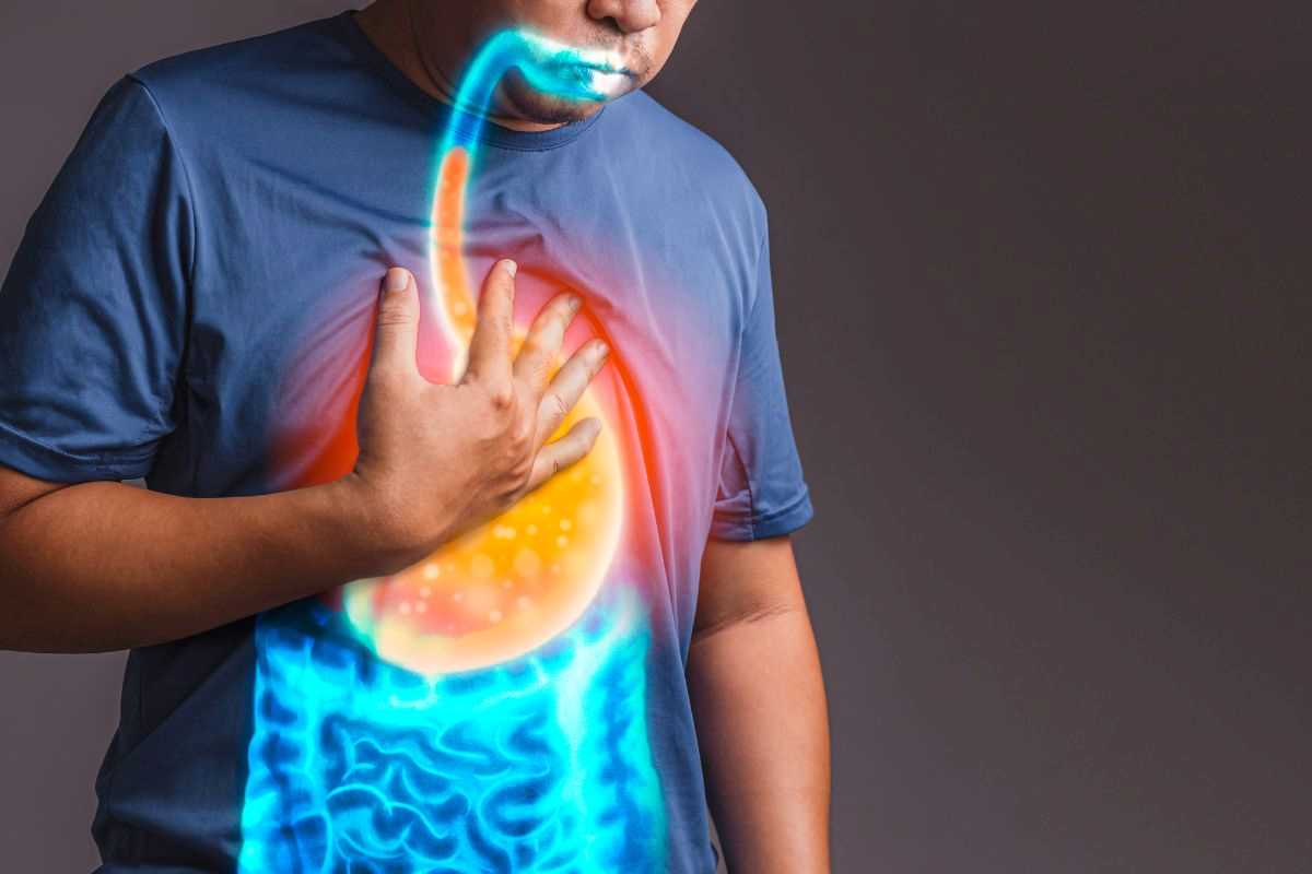 uomo con bruciore e pesantezza allo stomaco dovuti al reflusso