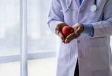 un medico con un cuore di legno in mano