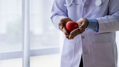 un medico con un cuore di legno in mano