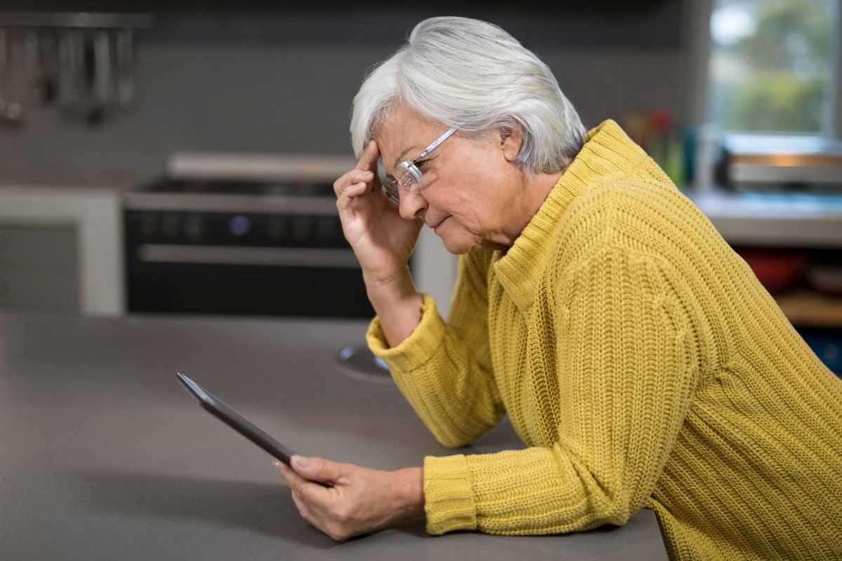 donna anziana che guarda confusa un tablet