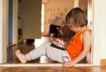 una bambina gioca con un tablet sulle ginocchia