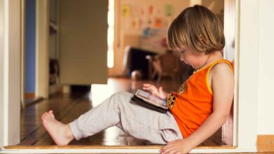 una bambina gioca con un tablet sulle ginocchia