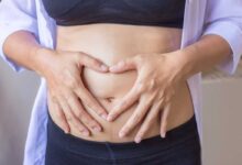una donna si mette le mani sull'addome gonfio
