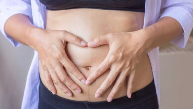 una donna si mette le mani sull'addome gonfio