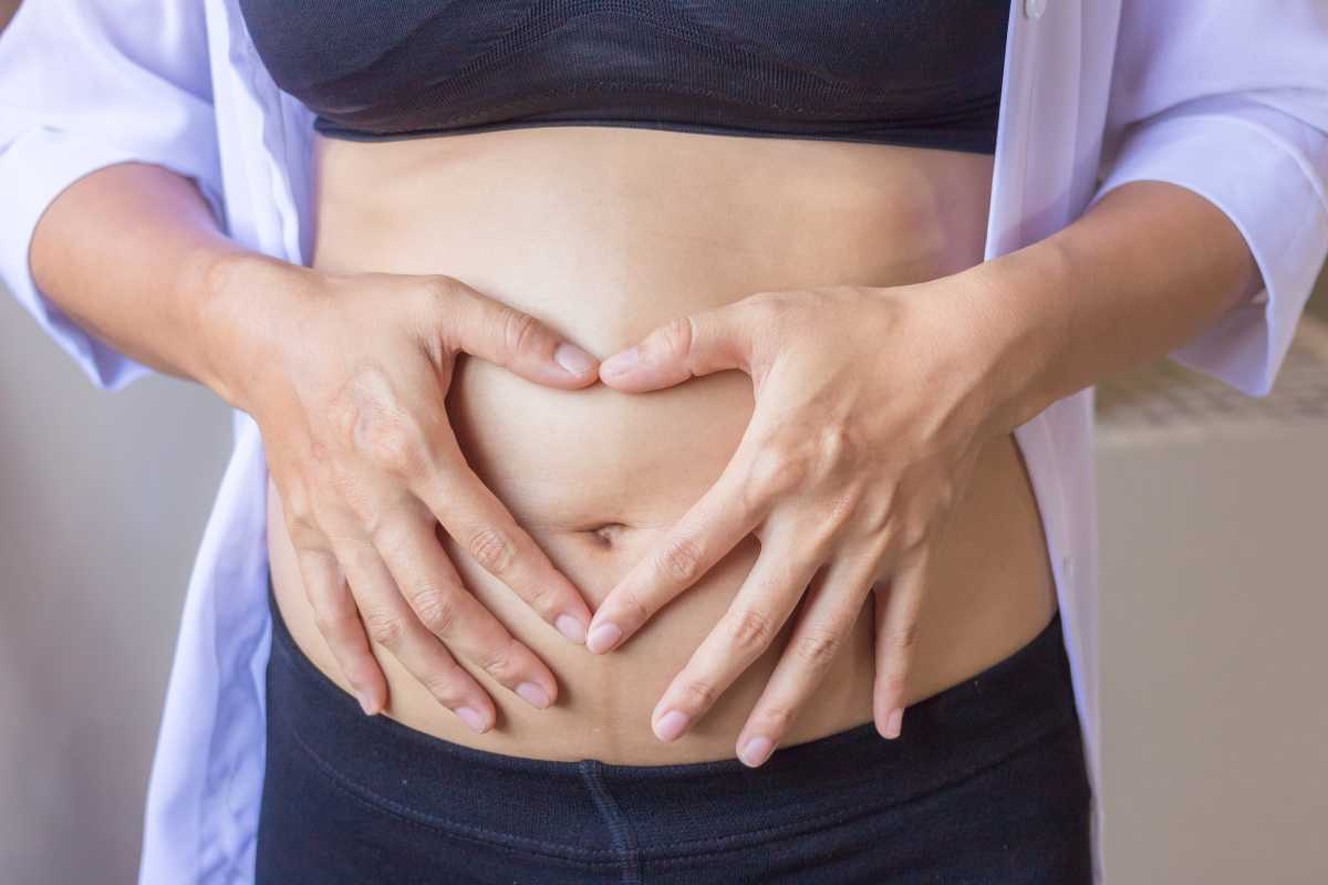 una donna si mette le mani sull'addome gonfio