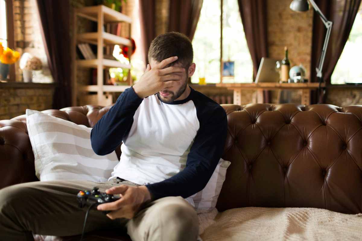 un uomo in preda all'ansia davanti a un videogioco