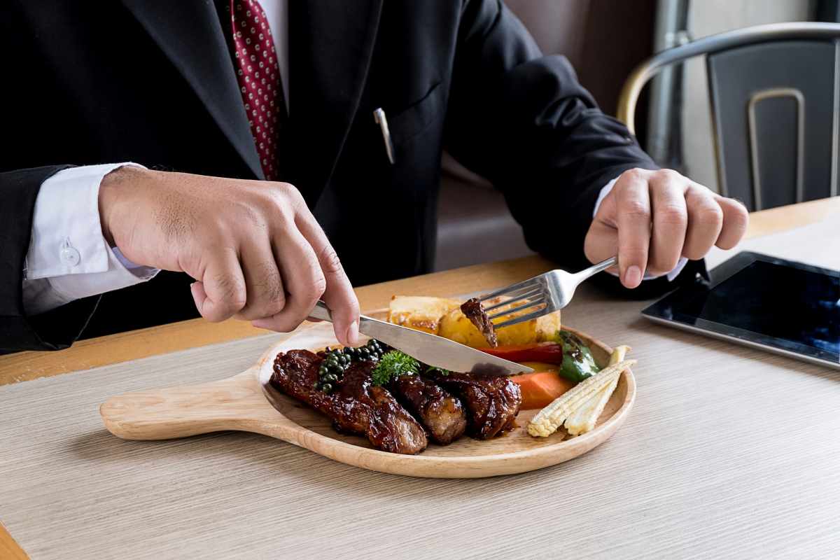 uomo d'affari mangia una bistecca in pausa pranzo