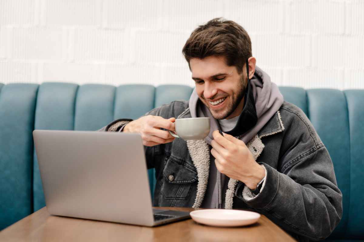 ragazzo che beve un caffè e parla al computer