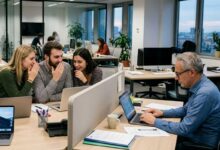 gruppo di ragazzi giovani sul luogo di lavoro che fa ageismo nei confronti di un collega più anziano