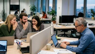 gruppo di ragazzi giovani sul luogo di lavoro che fa ageismo nei confronti di un collega più anziano
