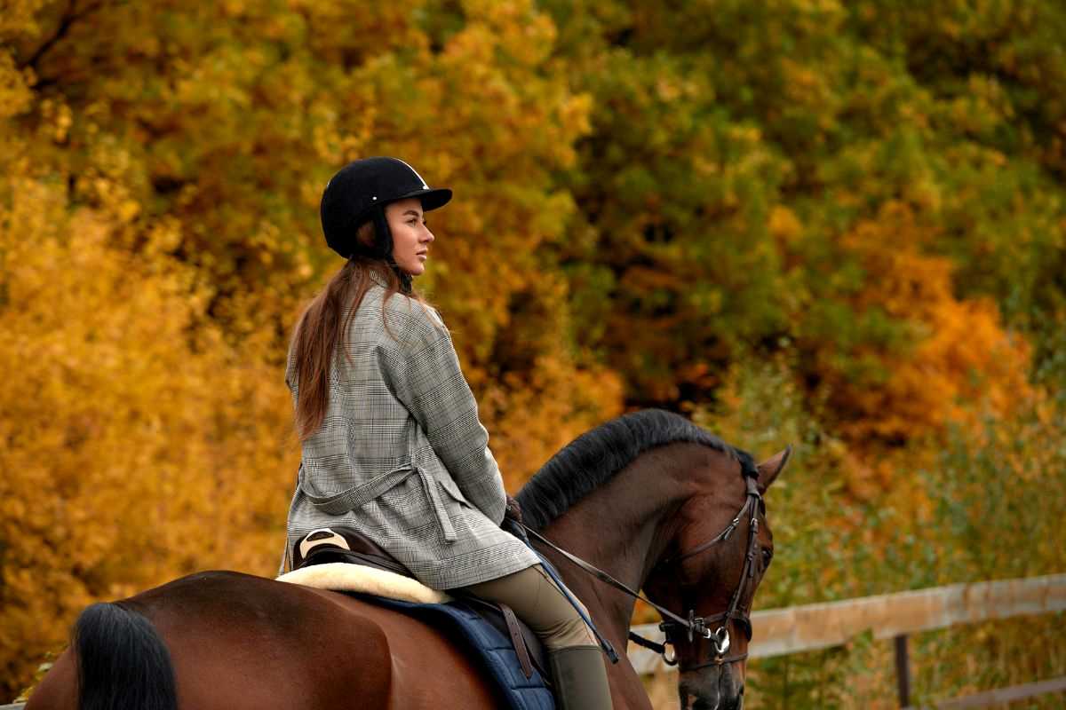 donna che va a cavallo in autunno nel bosco