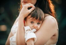 bimba con il ciuccio in braccio alla sua mamma