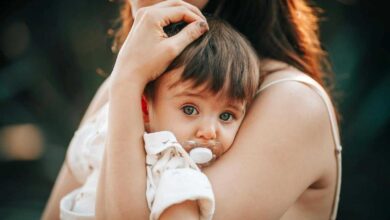 bimba con il ciuccio in braccio alla sua mamma