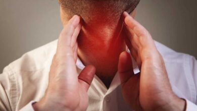 uomo che tocca con le mani la gola in prossimità di cisti alle corde vocali