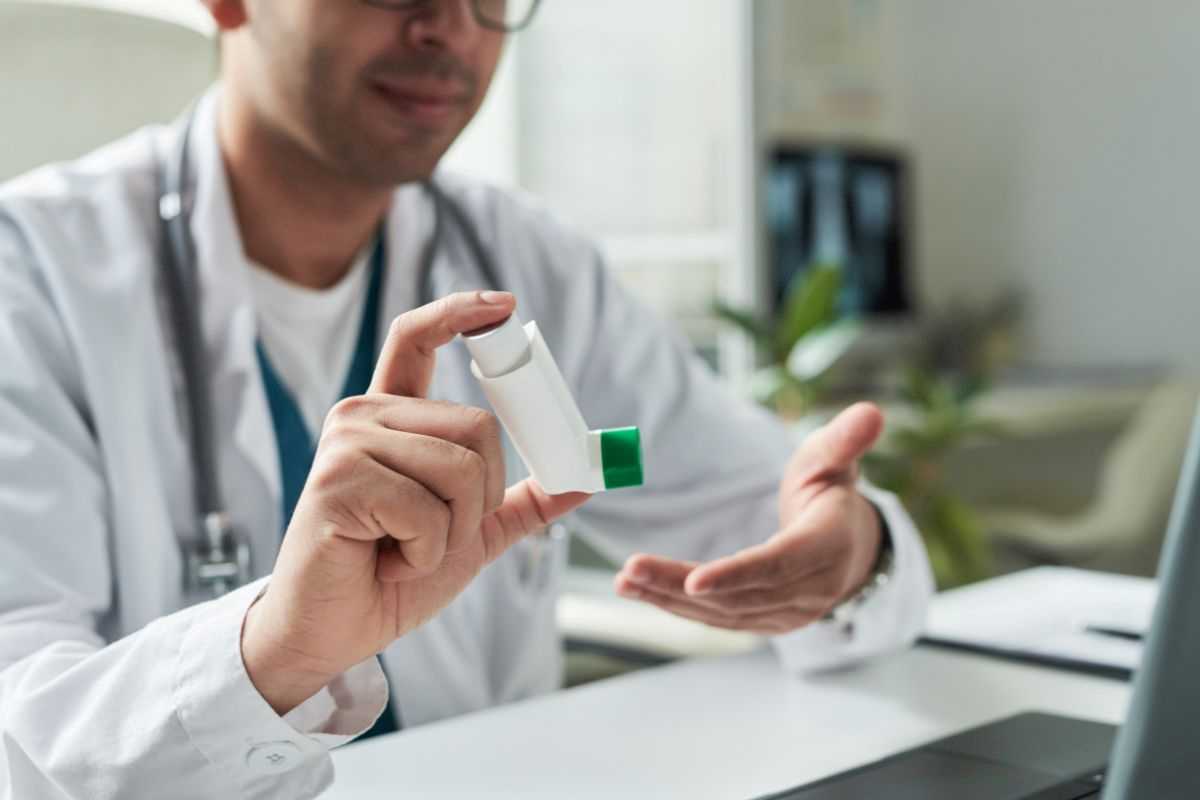 medico che mostra il dispositivo spray al cortisone per asma
