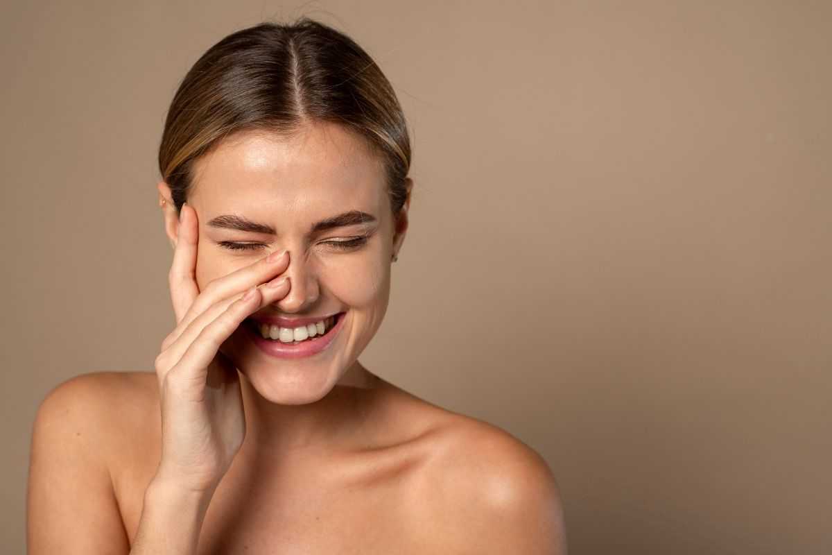 donna sorridente che mostra pelle luminosa grazie alla beauty routine herbalife