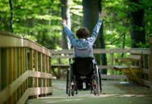 ragazzino di spalle sulla sedia a rotelle con distrofia di duchenne