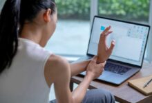 donna con dolore e formicolio alla mano al computer