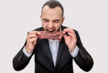 un uomo addenta una fettina di carne rossa