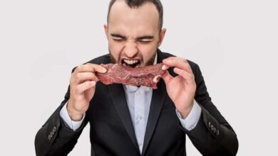 un uomo addenta una fettina di carne rossa