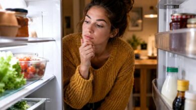 donna che in autunno ha sempre fame e cerca in frigo qualcosa da mangiare