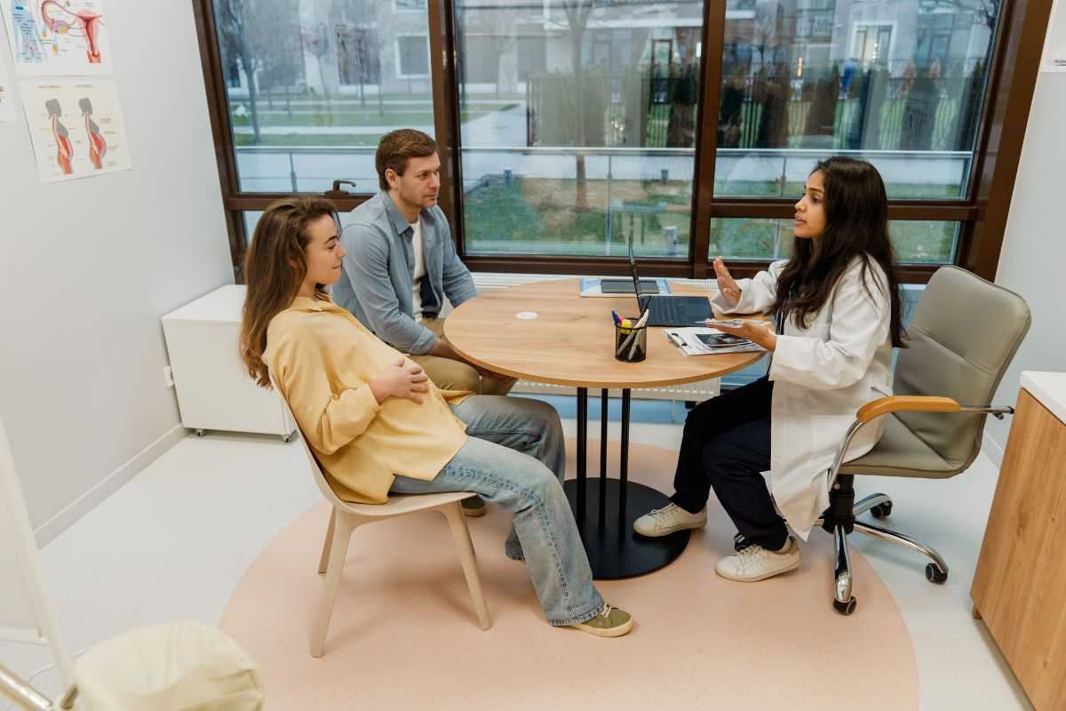 coppia di futuri genitori a colloquio con una dottoressa