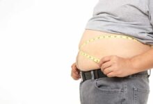 prima piano sull'addome grasso di una persona con il centimetro da sarte nel punto vita