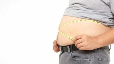 prima piano sull'addome grasso di una persona con il centimetro da sarte nel punto vita