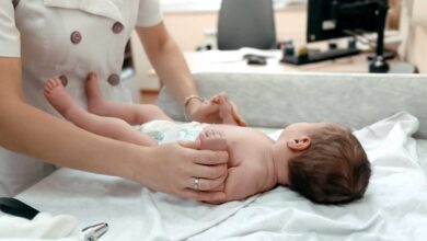 pediatra che visita neonato per individuare la malattia rara lipasi acida lisosomiale